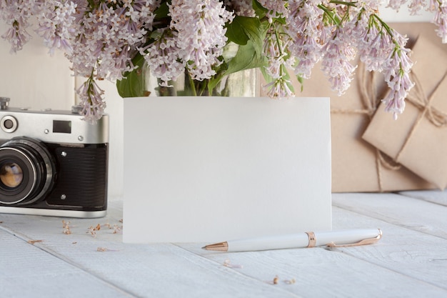 Carte de voeux blanche vierge avec bouquet de fleurs lilas.