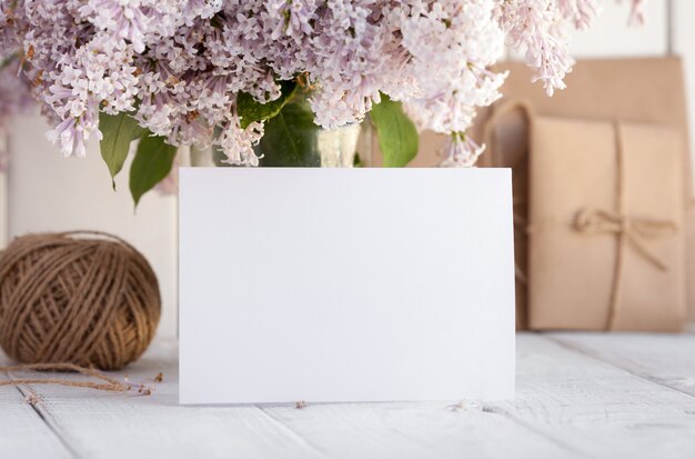 Carte de voeux blanche vierge avec des fleurs lilas.