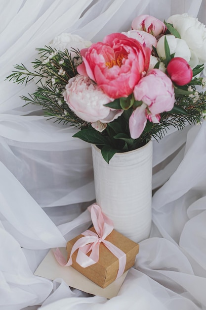 Carte de voeux cadeau bouquet de pivoines élégantes sur fond de tissu blanc doux Bonne fête des mères