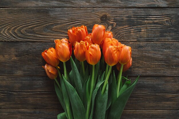 Carte de voeux élégante Tulipes fraîches à plat sur fond de bois Modèle de carte de voeux floral avec un espace pour le texte Bonne fête des femmes Bonne fête des mères Carte de voeux élégante