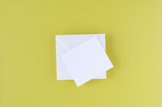 Carte de voeux avec enveloppe blanche sur fond jaune