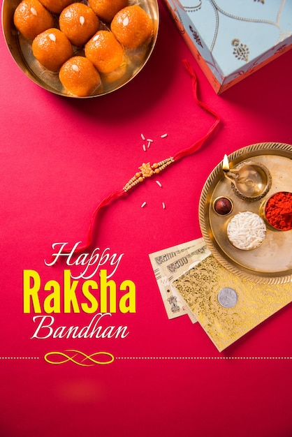 Carte de voeux Happy Raksha Bandhan ou Rakhi utilisant du fil Designer, Diya, Pooja Thali, coffret cadeau, billets et bonbons indiens, etc. Éclairage de mauvaise humeur, mise au point sélective