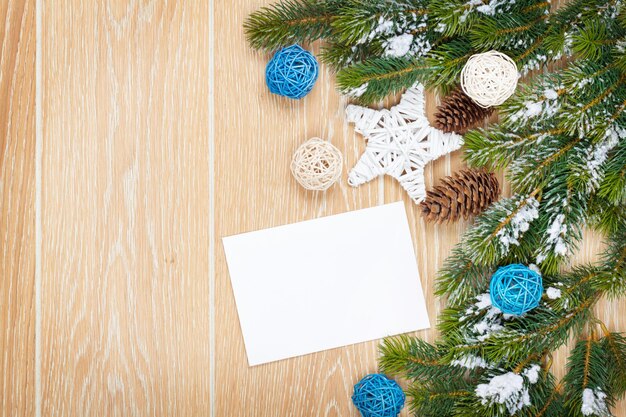 Carte de voeux de Noël ou cadre photo sur table en bois avec sapin de neige