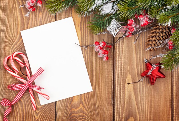 Carte de voeux de Noël ou cadre photo sur table en bois avec sapin de neige