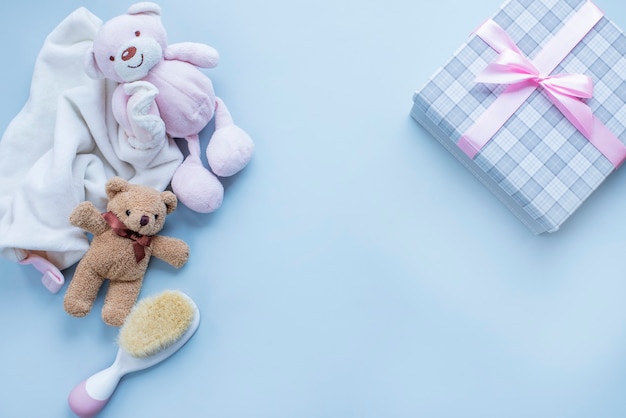 Carte de voeux pour la naissance de bébé fille avec ours en peluche et brosse à cheveux bébé sur une surface gris clair Image avec espace de copie