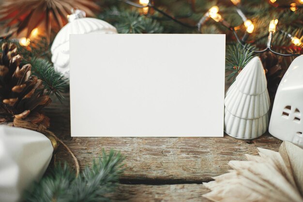 Carte de voeux vide et papier de noël étoiles boules cônes branches de pin lumières Xmas Mock up