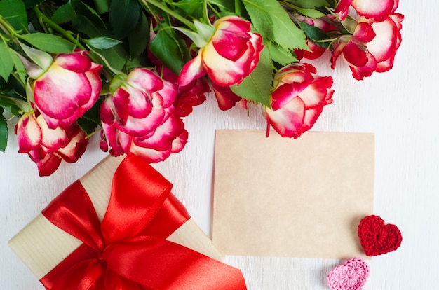 Carte de voeux vide, roses rouges et boîte-cadeau