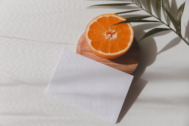 Carte de voeux vierge joyeux anniversaire fruit orange et une feuille de palmier verte sur fond blanc Invitation de mariage d'été vue de dessus espace de copie plat