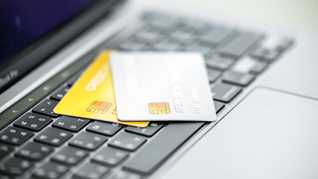 Cartes de crédit sur le clavier de l'ordinateur portable Libre accès pour les achats en ligne Carte de crédit gros plan avec mise au point sélective Concept d'achat et de paiement en ligne