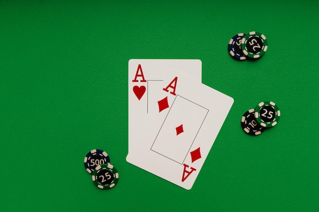 Cartes à jouer avec des as et des jetons sur un concept de casino de table verte