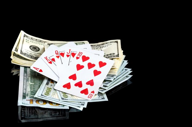 Cartes à jouer et dollars sur fond noir