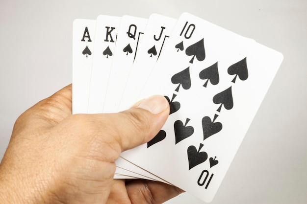 Photo cartes à jouer quinte flush royale en main sur fond blanc
