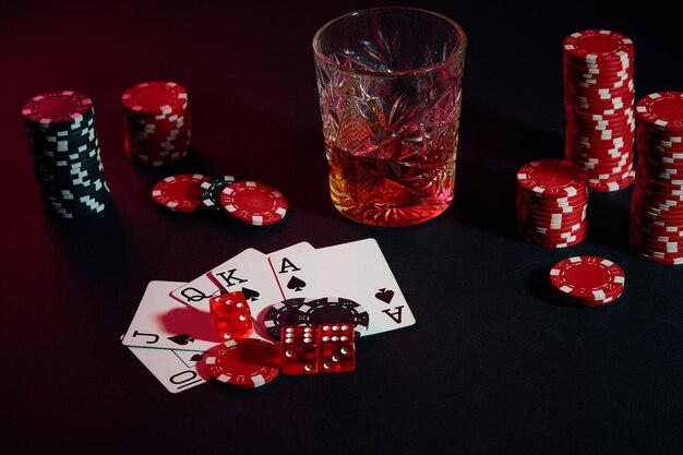 Cartes de joueur de poker. Sur la table, des chips et un verre de cocktail au whisky. Combinaison de cartes - Quinte Royale