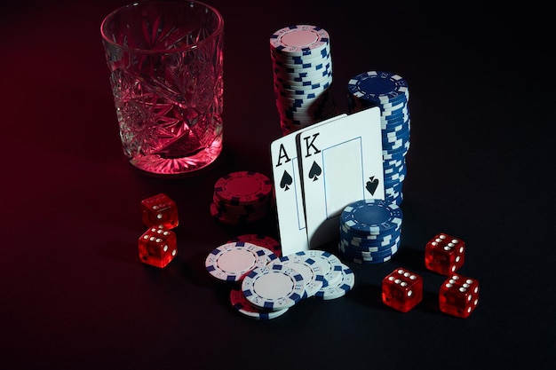 Cartes de joueur de poker. Sur la table, des chips et un verre de cocktail au whisky. Nature morte. Le concept de jeu. Poker en ligne. Cartes - As et Roi