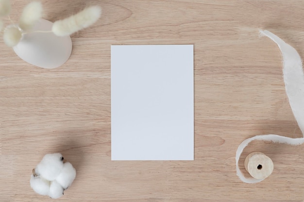 Cartes de papier vierges, Invitation de carte de vœux vierge Maquette avec herbe de queue de lapin séchée dans un vase sur une table en bois, arrière-plan de bureau en bois, composition minimale du lieu de travail de table en bois, mise à plat, maquette