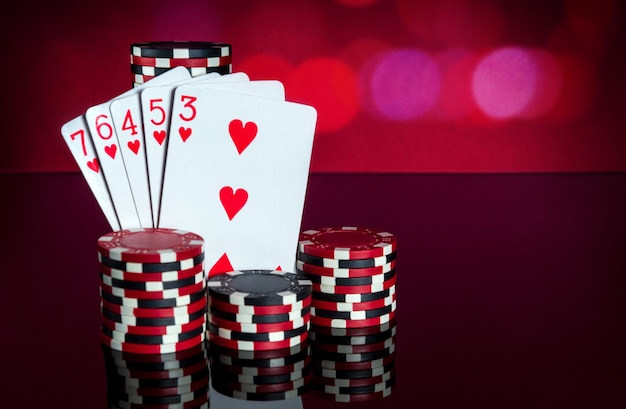 Cartes de poker avec une combinaison de quinte flush. Gros plan sur des cartes à jouer et des jetons dans un club de poker. Espace publicitaire gratuit