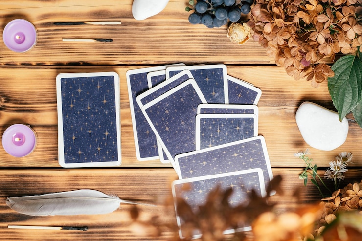 Les cartes de tarot s'étalent face cachée sur une surface en bois avec des bougies, des pierres, des plantes d'automne et des accessoires. Vue de dessus. Minsk, Biélorussie, 11.10.2021