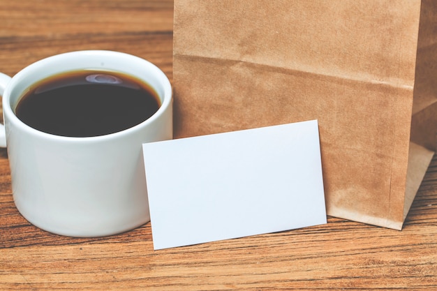 Cartes de visite en blanc et tasse de café sur une table en bois. La maquette de marque stationnaire d&#39;entreprise se moque.