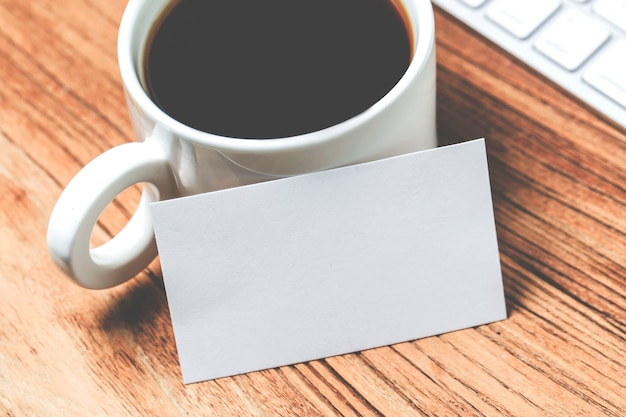 Cartes de visite en blanc et tasse de café sur une table en bois. La maquette de marque stationnaire d&#39;entreprise se moque.