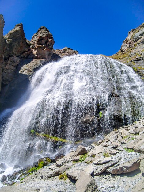 La cascade au débit rapide L'eau coule sur une falaise rocheuse