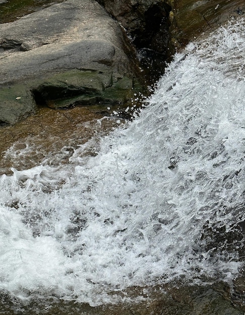 Une cascade est visible au premier plan et l'eau est blanche.