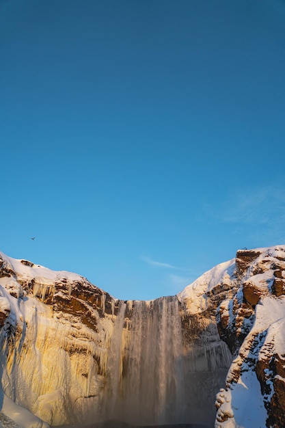 Cascade géante de Skogafoss entièrement recouverte de neige et la rivière est passée