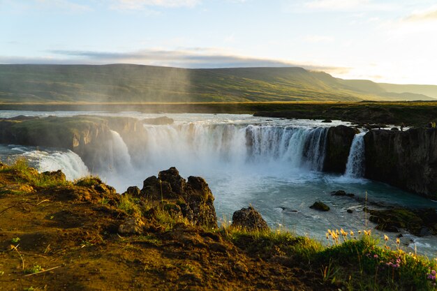 Cascade islandaise brumeuse au coucher du soleil