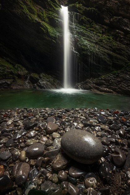 Une cascade de pierres et de feuilles d'automne se trouve dans l'eau