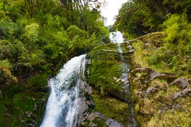 Une cascade avec un pont en bois dans le village de Thangyam de Taplejung Kanchenjunga Trek Népal