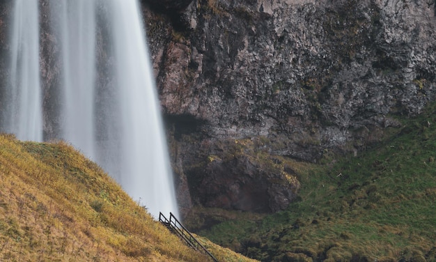 Cascade de Seljalandfoss en Islande longue exposition avec des escaliers en bois