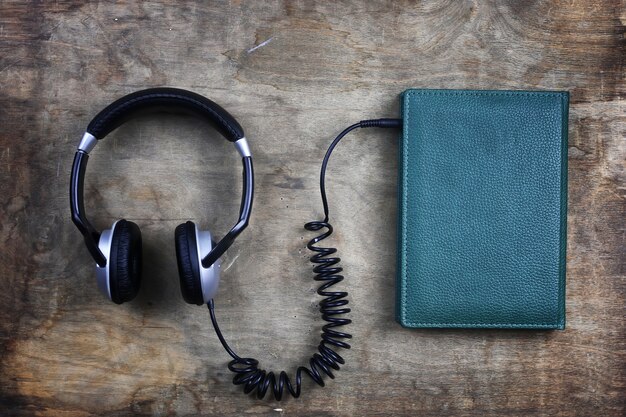 Casque audio et livre sur une table en bois
