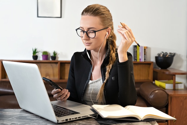 Casque de baguette de lunettes femme et ordinateur portable étudiant travaillant en ligne