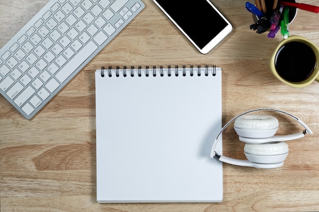 Casque blanc empiler sur du papier livre blanc sur la table de travail en bois