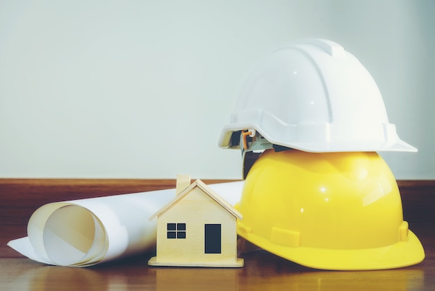 Casque blanc et jaune avec des maisons en bois et divers appareils placés sur un plancher en bois.