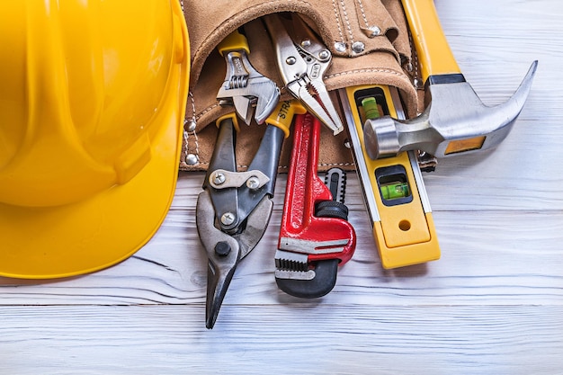 Casque de construction de ceinture à outils en cuir sur le concept d'entretien de planche de bois