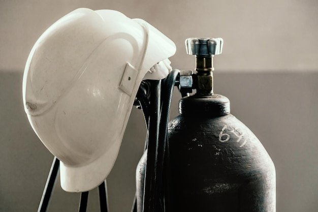 Le casque de construction est porté sur la bouteille d'oxygène dans l'atelier de soudage Industrie et construction