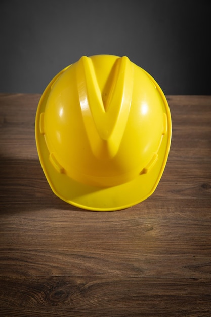 Casque de construction jaune sur la table en bois