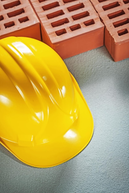 Casque dur de briques de construction sur le concept de construction de surface en béton.