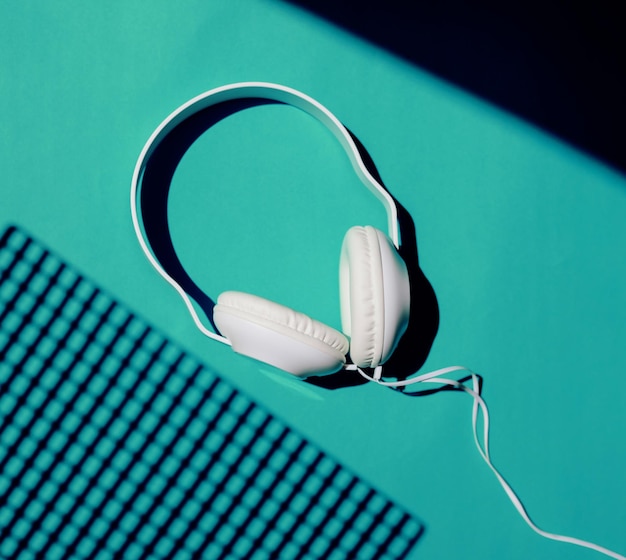 Casque sur fond bleu Un concert de musique Vue d'en haut Photo colorée à la mode Ombres géométriques une petite grille de carrés