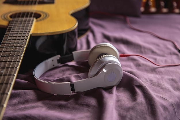 Casque et guitare classique au lit