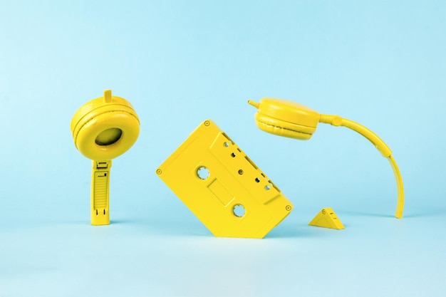 Casque jaune et cassettes de bande se noyant dans un fond bleu Style vintage dans l'enregistrement sonore Concept audio minimal