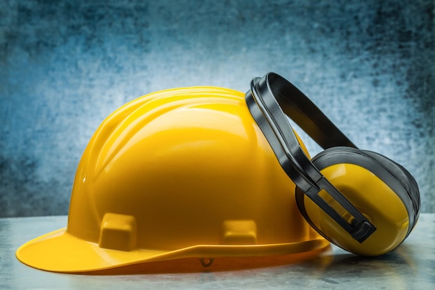 Casque jaune de construction et écouteurs sur fond métallique