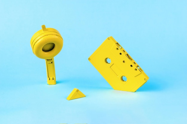 Casque jaune et un magnétophone plongeant dans un fond bleu Image abstraite de l'équipement d'enregistrement rétro