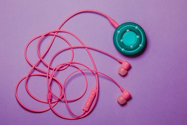 Casque et lecteur emmêlés colorés sur fond lilas