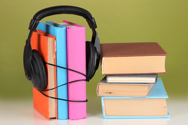 Casque sur les livres sur fond vert