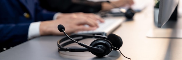 Photo casque de mise au point panoramique sur le bureau de l'espace de travail du centre d'appels avec l'opérateur de flou prodigy