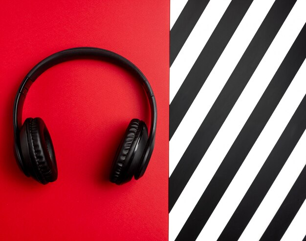 Casque noir sur fond rouge. Concept minimal. Mise à plat.