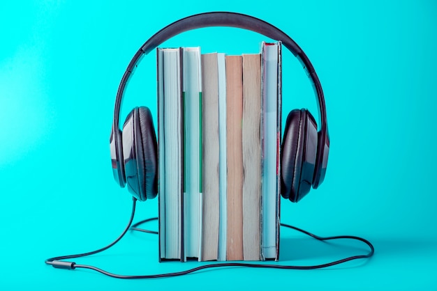 Casque Noir Avec Une Pile De Livres Sur Un Fond Bleu.