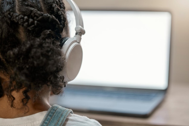 Casque pour fille et écran d'ordinateur portable dans la classe d'enseignement à domicile en elearning ou soutien à l'étude dans le verrouillage ou la quarantaine de la maison Casque Zoom et enfant sur le logiciel de technologie étudiante avec espace de maquette