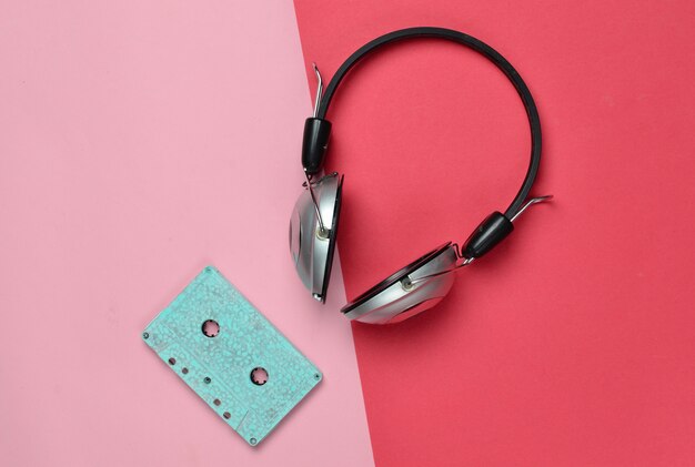 Casque sans fil et cassettes audio sur papier pastel multicolore.